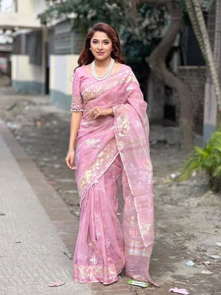 This is an image of a woman wearing a light muslin powder pink saree for Mahalaya
