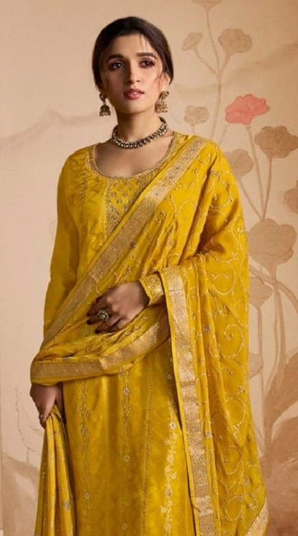 This is an image of a woman wearing a yellow and gold Anarkali suit 