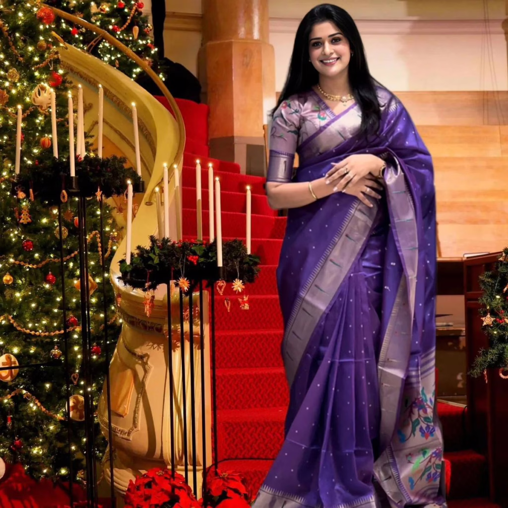 This is an image of a woman wearing a purple heavy silk saree 