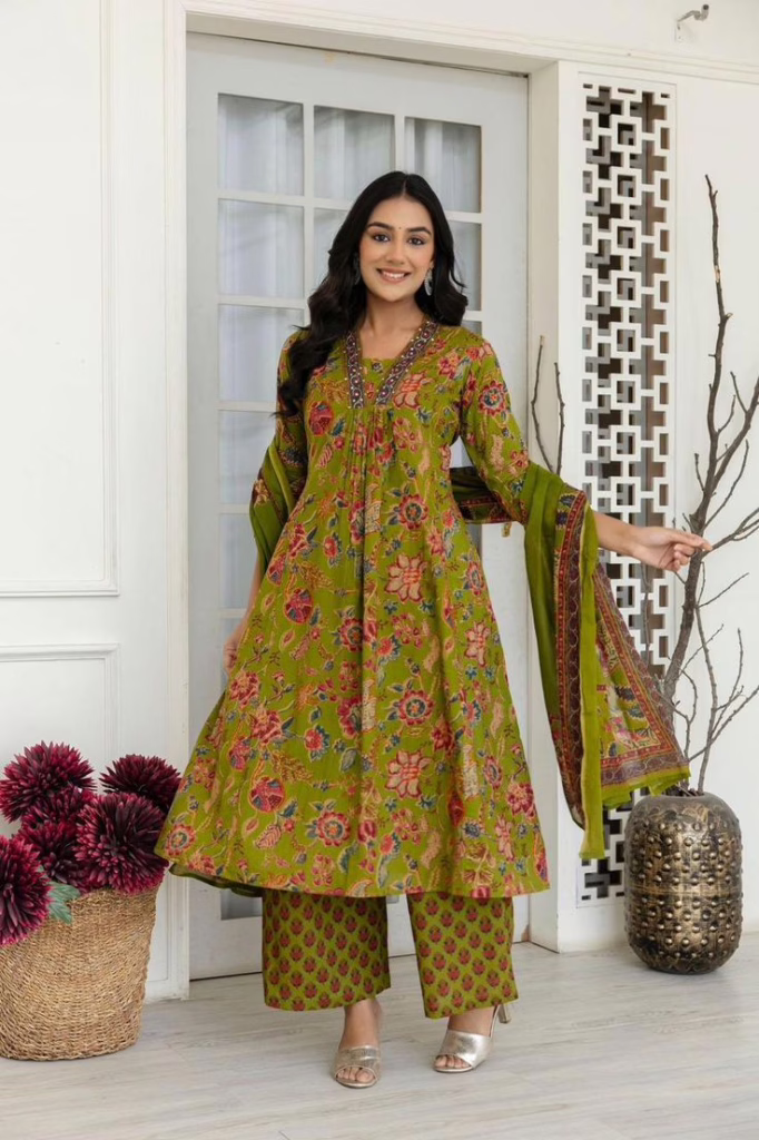 This is the image of a woman wearing a green nature inspired Kurti with pink and maroon motifs 