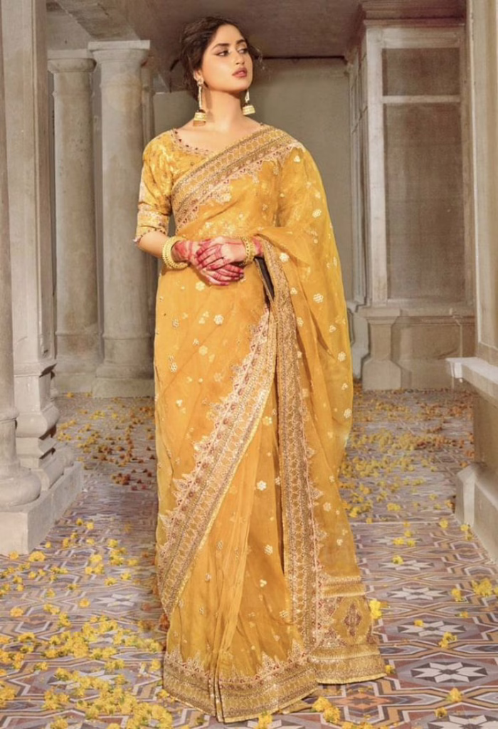 Woman wearing a georgette yellow bananasi saree 