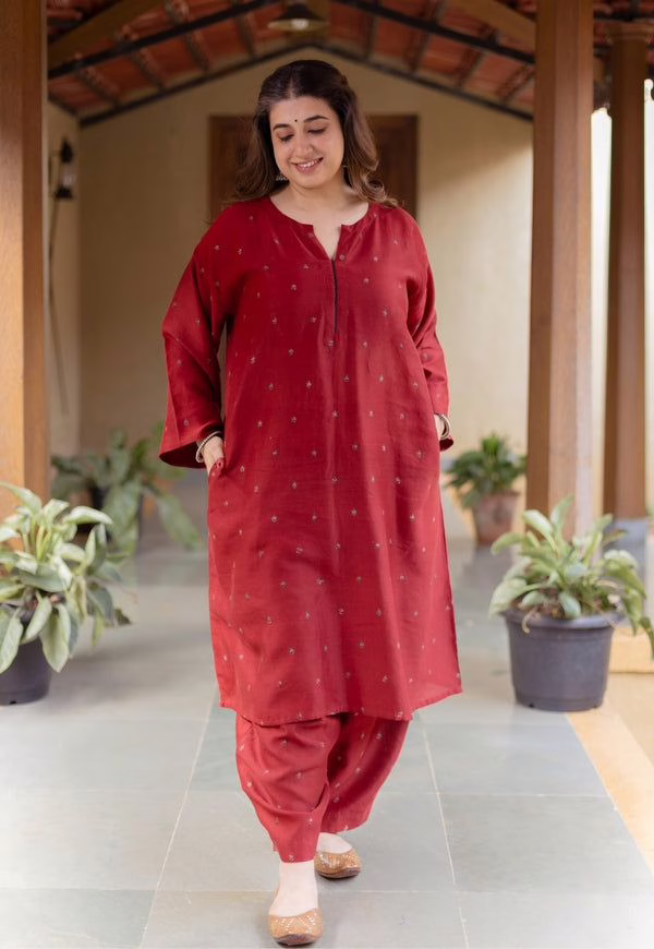 A lady wearing a red A- Lined Kurti that is one of the best kurti styles for Apple- Shaped body type women Photo credits: Pinterest 