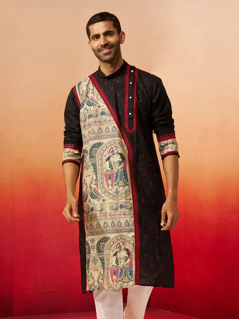 Man wearing a black traditional kurta with intricate ethnic artwork, red embroidery, and white trousers.