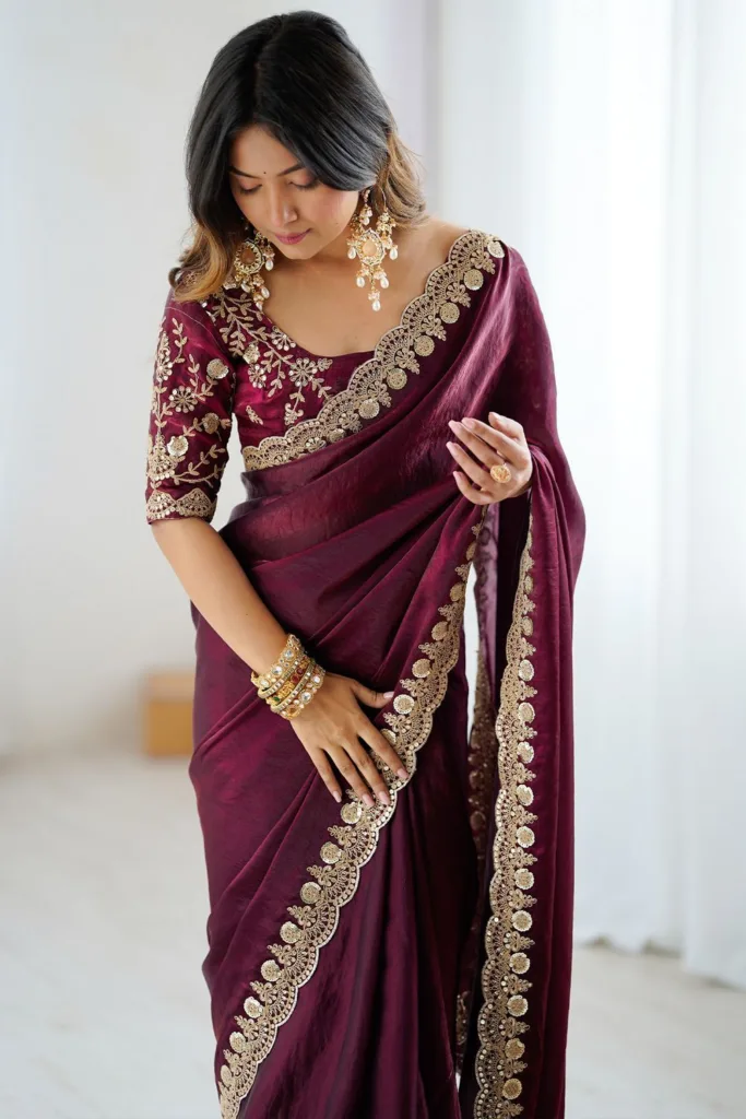 5 Super Simple Tips to Choose Your Saree Fall for the Perfect Drape 2 5 Super Simple Tips to Choose Your Saree Fall for the Perfect Drape Image of a woman holding her saree pleats of a dark maroon saree with a gold border.
