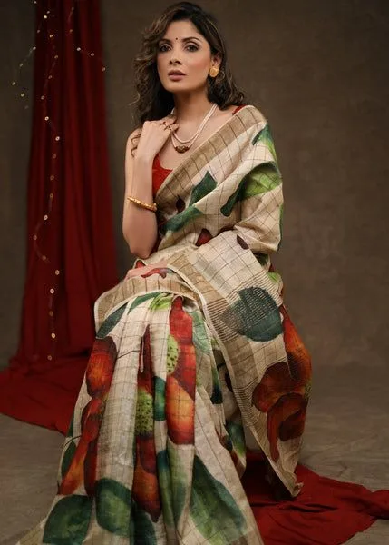 Woman wearing a beige monsoon-friendly saree with colorful leaf prints and a matching red blouse. The lightweight saree offers comfort and elegance, making it a perfect choice for festive occasions, casual outings, and everyday ethnic wear.