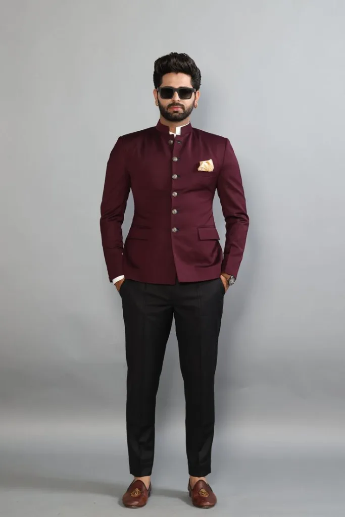 A man wearing a Maroon colored Bandhgala suit with black trouser