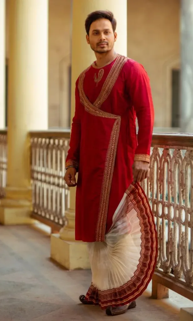 This is the picture of a man wearing a red pajama and a white dhoti with a cream border.
